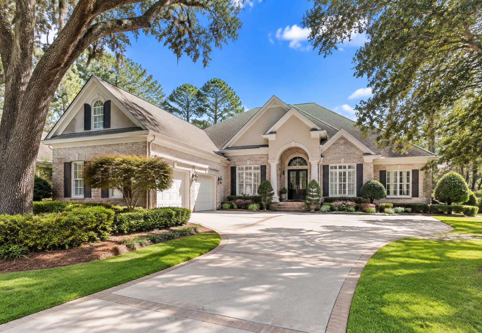 Upscale brick home in Killearn with a clean exterior, wide driveway and mature live oaks
